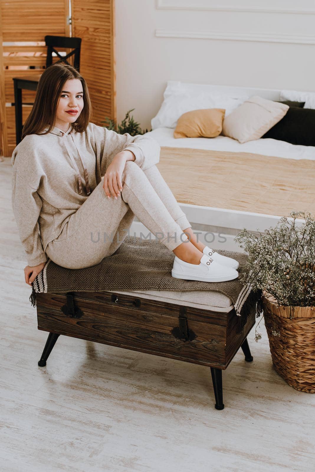 photo of a women in beige sports suit and stylish white leather sneakers posing on a bench. selective focus by Ashtray25