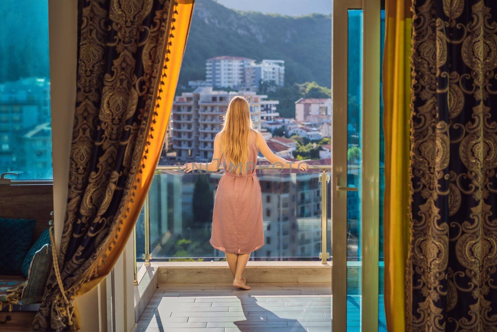 Woman on the balcony against the backdrop of mountains and city, Montenegro. life terrace pretty happiness summer home. Inspiration city romantic hotel.