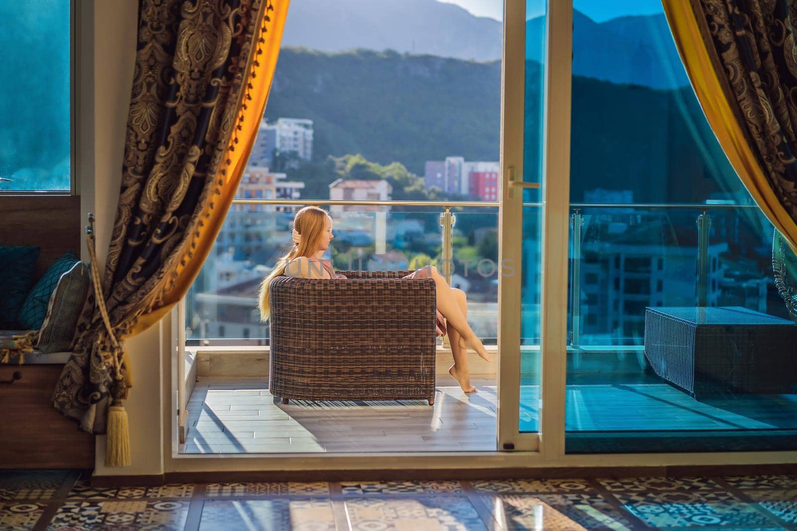 Woman on the balcony against the backdrop of mountains and city, Montenegro. life terrace pretty happiness summer home. Inspiration city romantic hotel by galitskaya