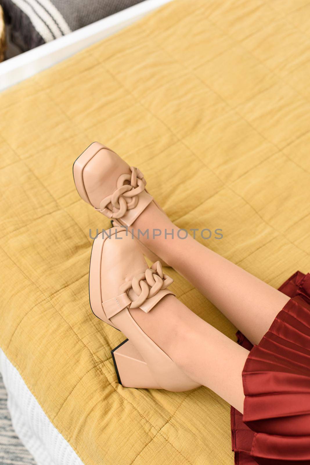 Photo of a womens legs in beige high-heeled shoes with a chain buckle by Ashtray25