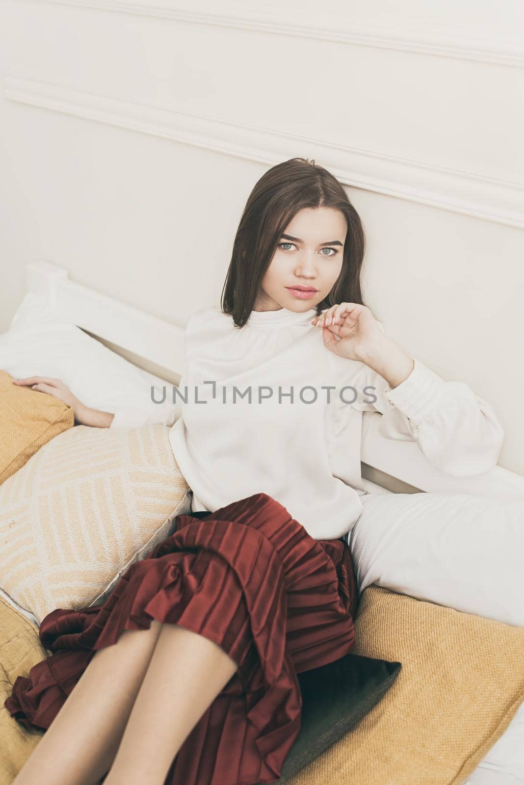 Portrait of fashionable women in red skirt, white blouse posing in a bed by Ashtray25