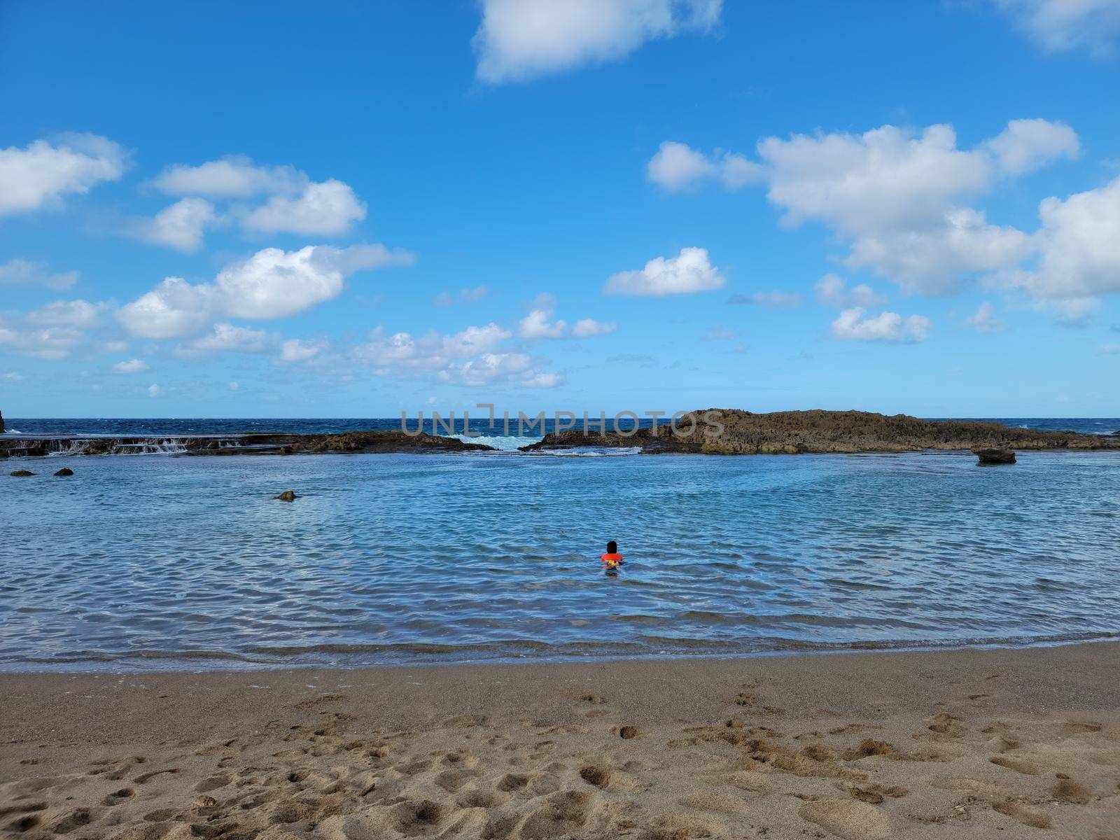 child swimming at beach with ocean in Isabela, Puerto Rico