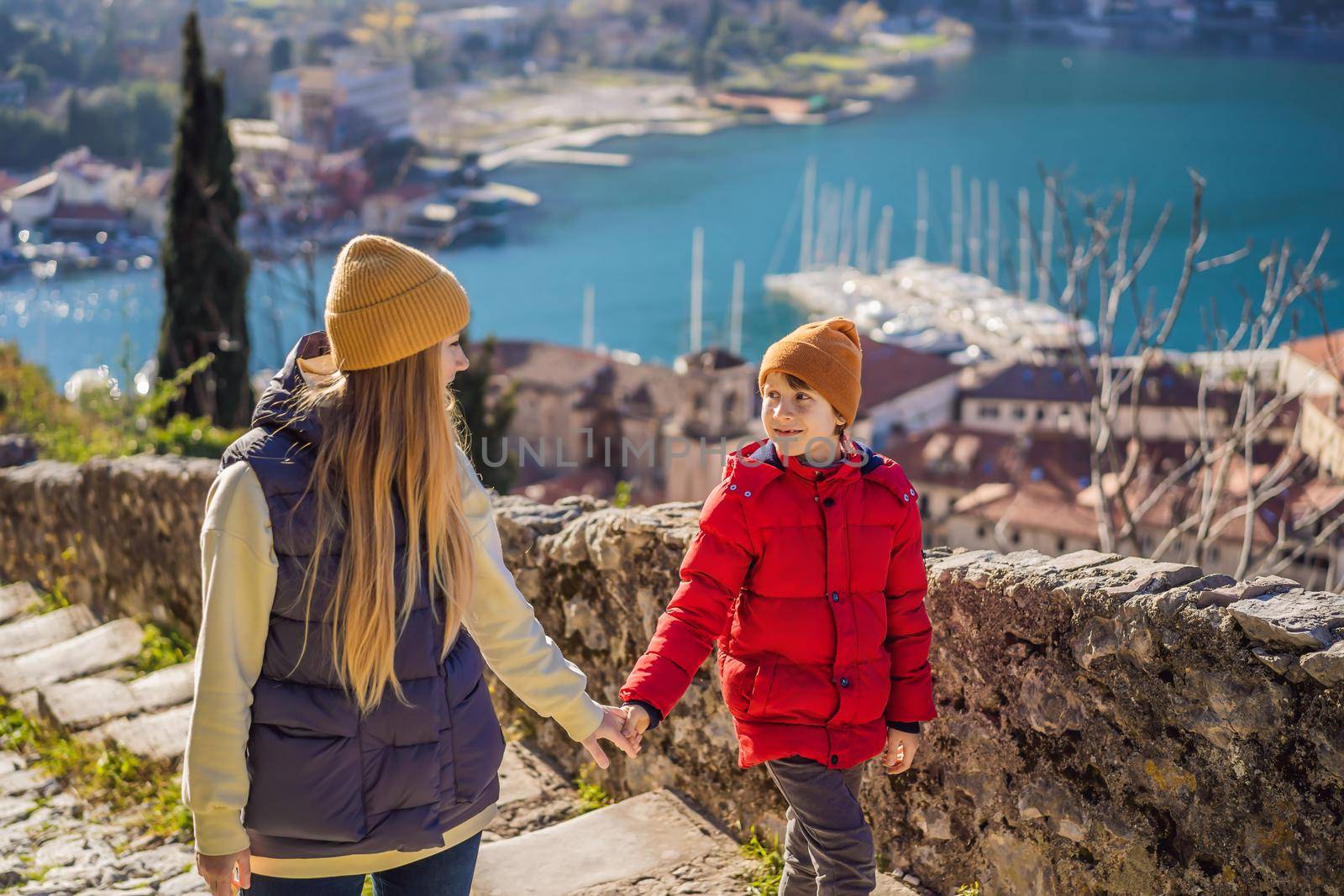 Mom and son travelers in Montenegro in Kotor Old Town Ladder of Kotor Fortress Hiking Trail. Aerial drone view.