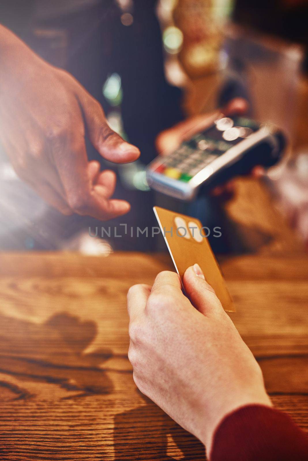 Closeup shot of a woman paying using NFC technology in a cafe.