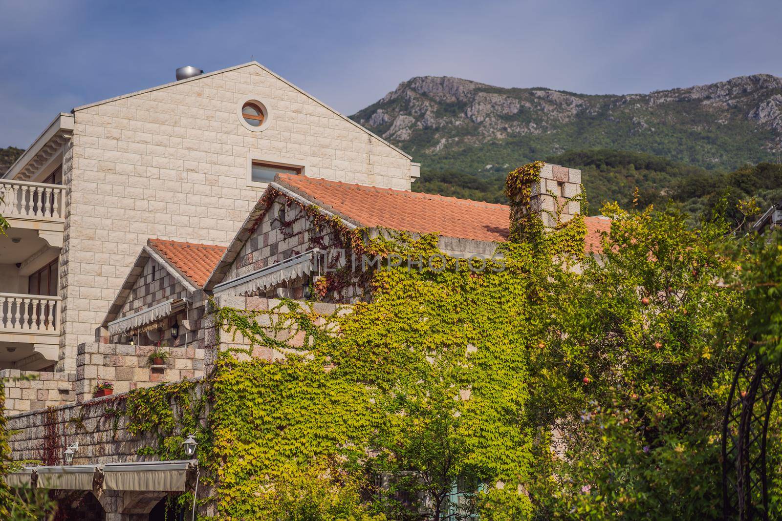 beautiful view of the mediterranean stone houses with a red tiled roofs and with balconies, the cozy yards, green trees, on a sunny summer day by galitskaya