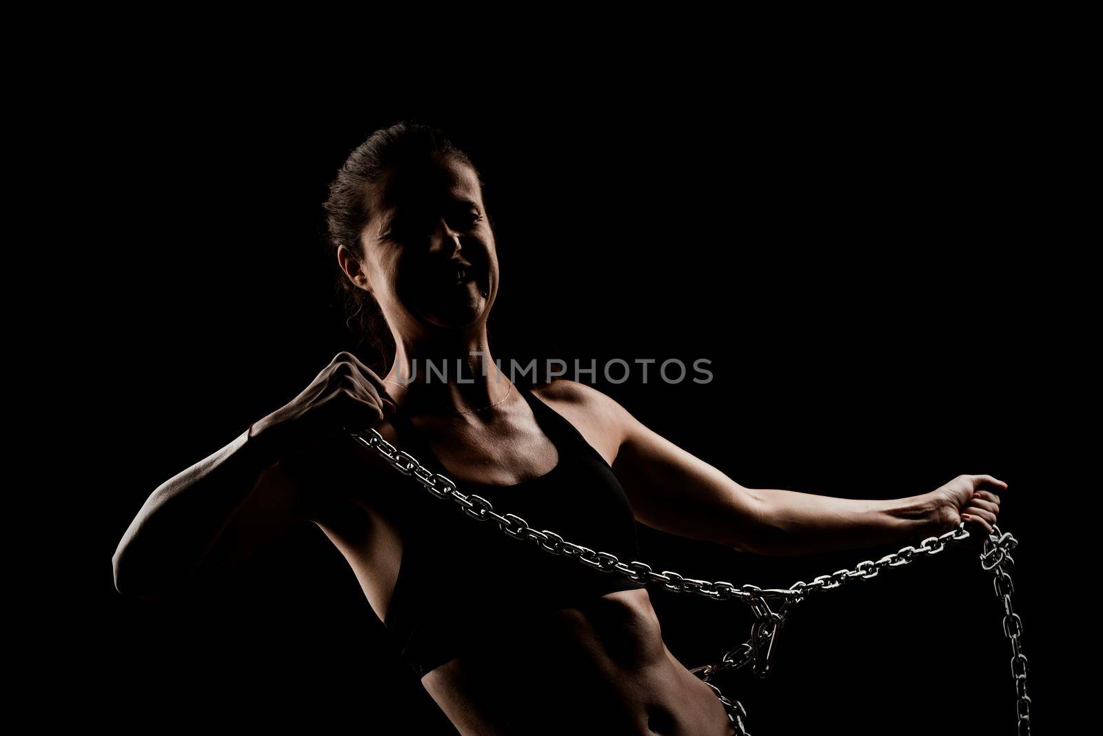 Strong fit girl with metal chain. Pulling and posing against black background.. by kokimk
