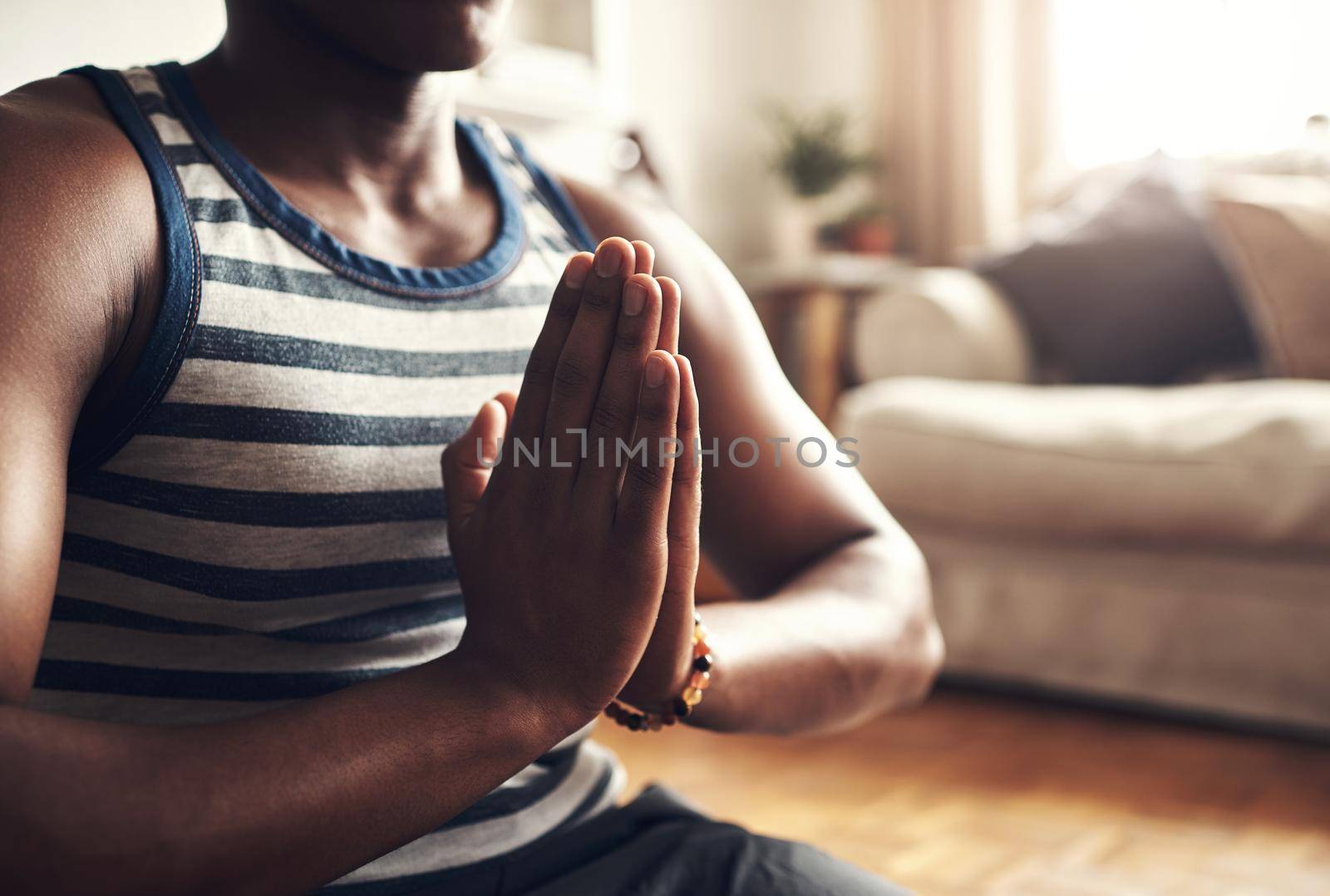 Closeup shot of an unrecognisable man meditating at home.