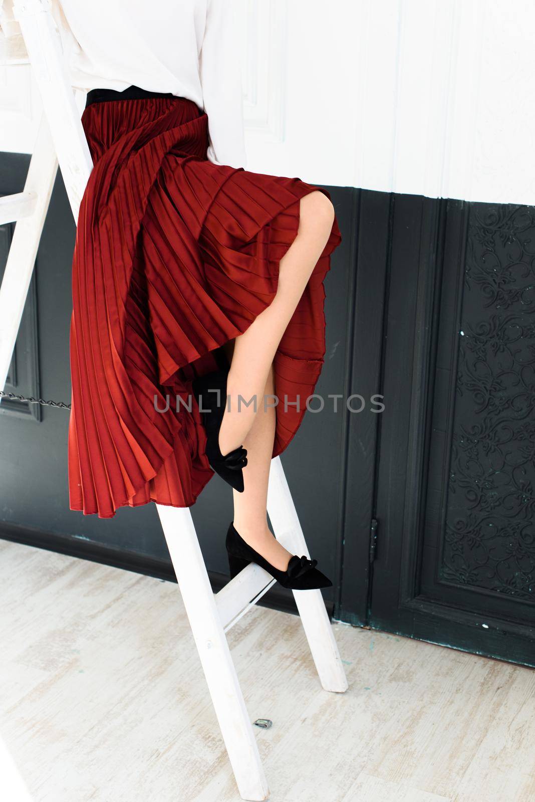 Photo of a womens legs in suede high-heeled shoes with a buckle. Selective focus