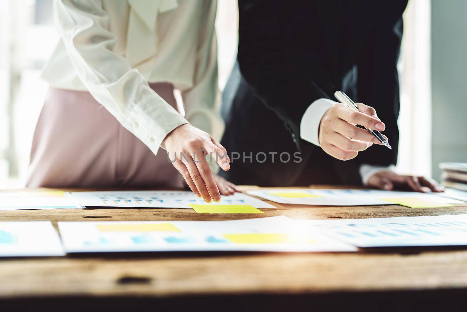 Brainstorming, Consulting, Data Analysis, Planning, Marketing and Accounting, Economist holding pen pointing to investment documents with partners on profit taking to compete with other companies