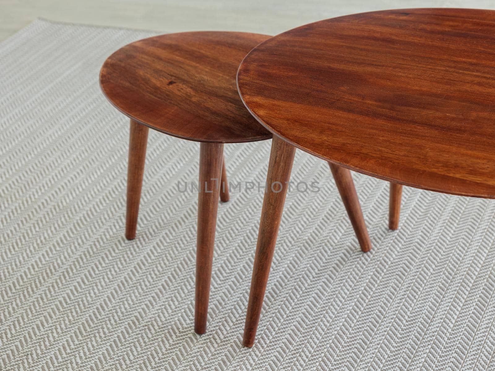 Double wooden table on carpet in interior of a living room or hotel. Empty surface furniture of brown color. by apavlin