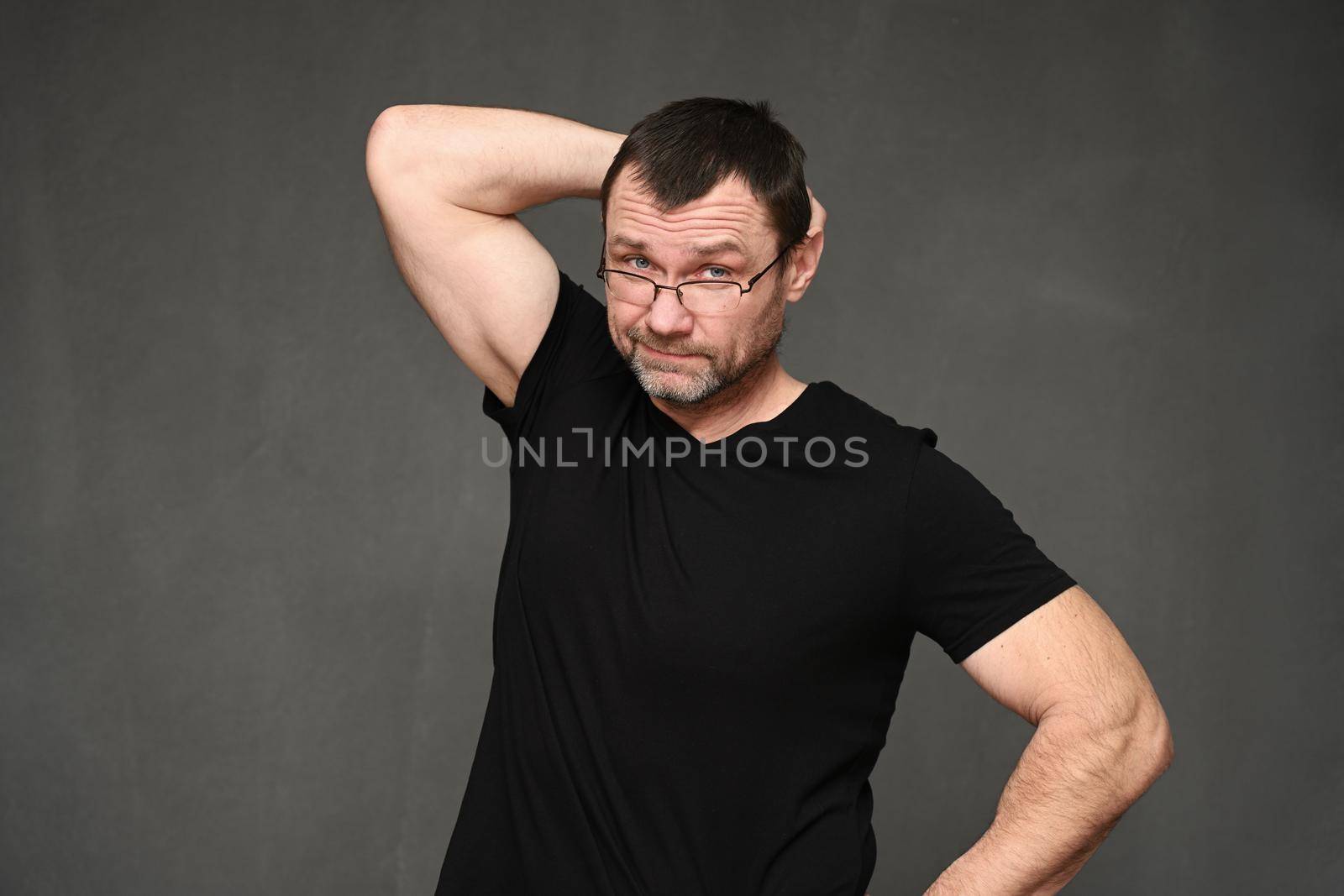 Adult caucasian man portrait in uncertainty over gray background