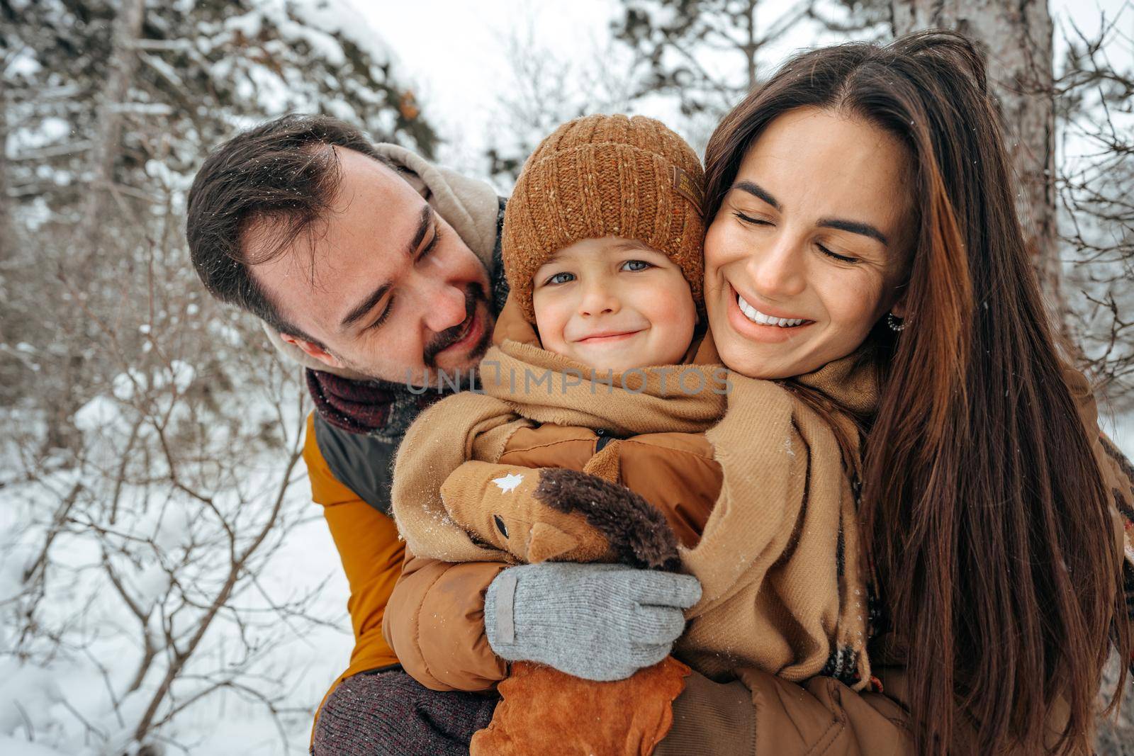 Portrait of happy family in winter clothes in snowy forest