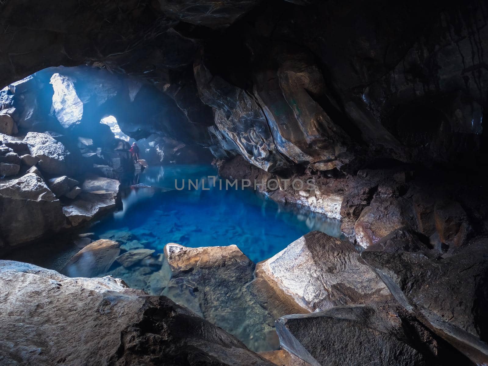 Deep blue lake inside the cave with unrecognizable photographer