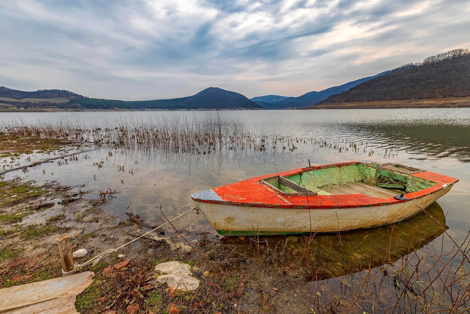 The idyllic mood on a  lakeshore with a wooden boat by EdVal