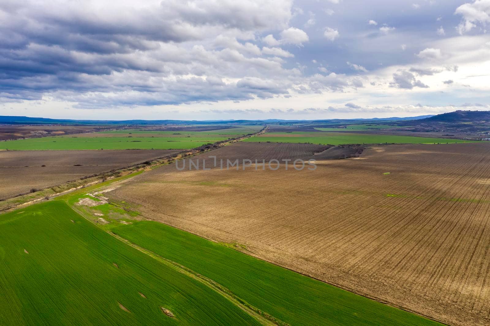 Amazing wide aerial view from drone of beautiful green countryside, fields, road, and cloudy sky by EdVal