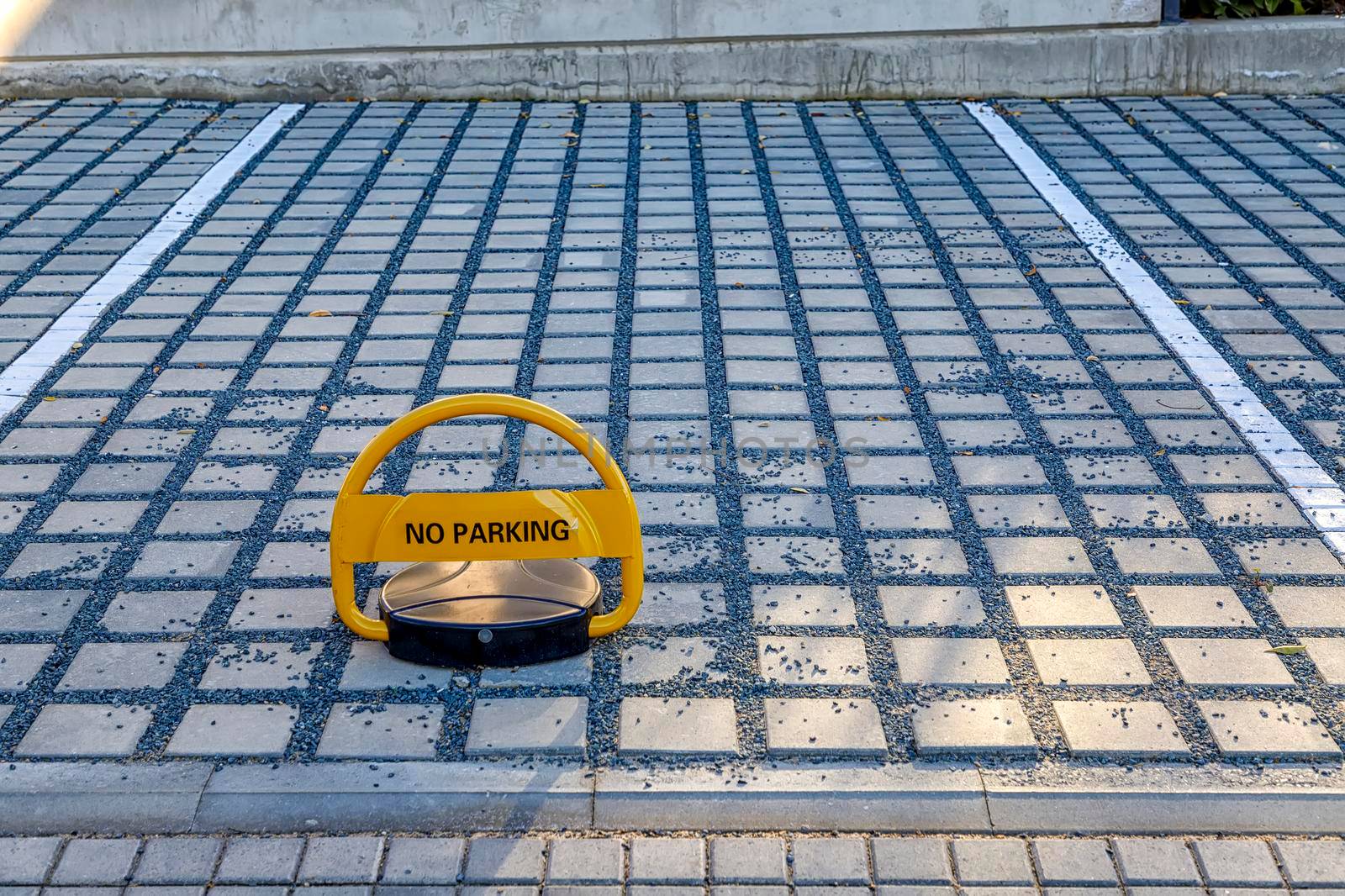 Parking lot barrier locked with padlock protecting  from improperly parked cars.