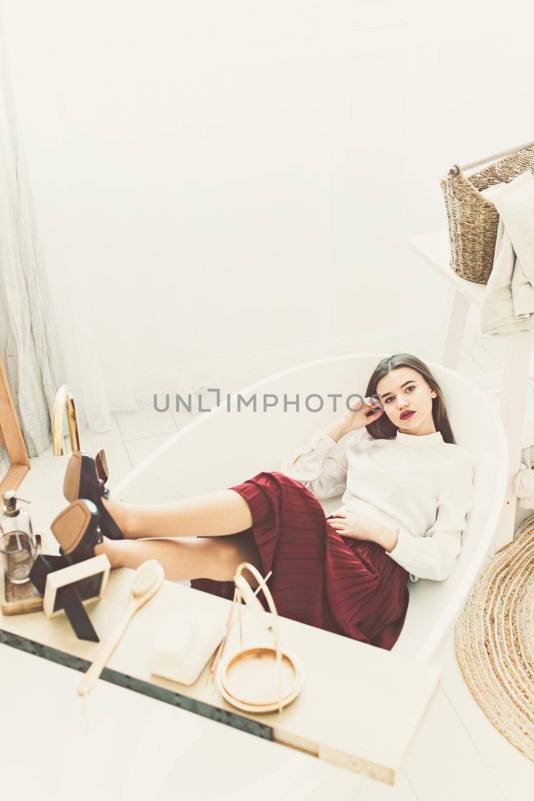 Portrait of fashionable women in red skirt, white blouse and stylish beige high-heeled shoes with a chain buckle posing in a bed by Ashtray25