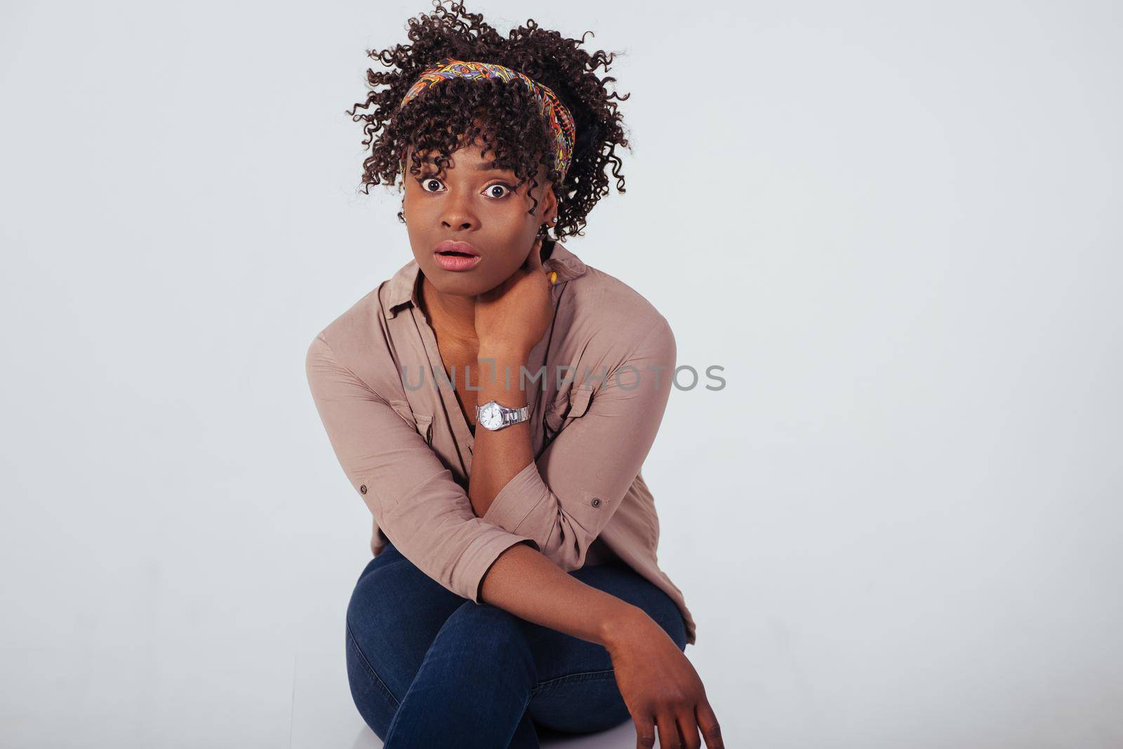 Surprised face. Beautiful afro american girl with curly hair in the studio with white background.