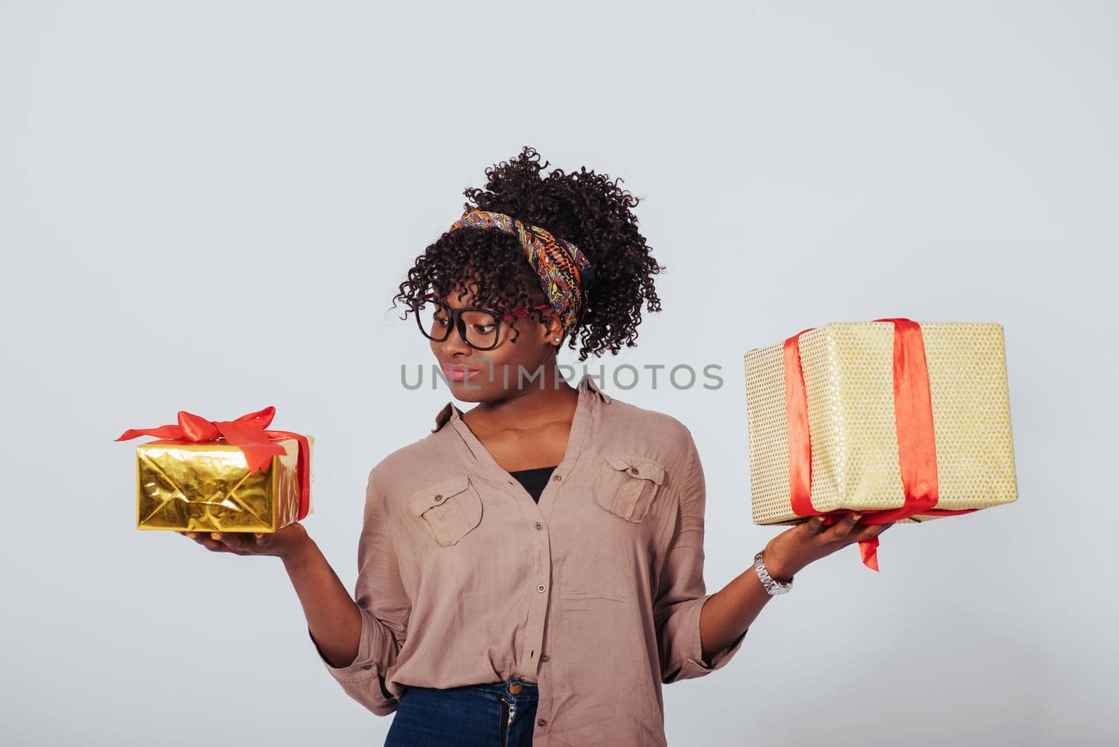 Small one for the kids and big one for adults. Holidays and celebration conception. Beautiful afro american girl with curly hair in the studio with white background.