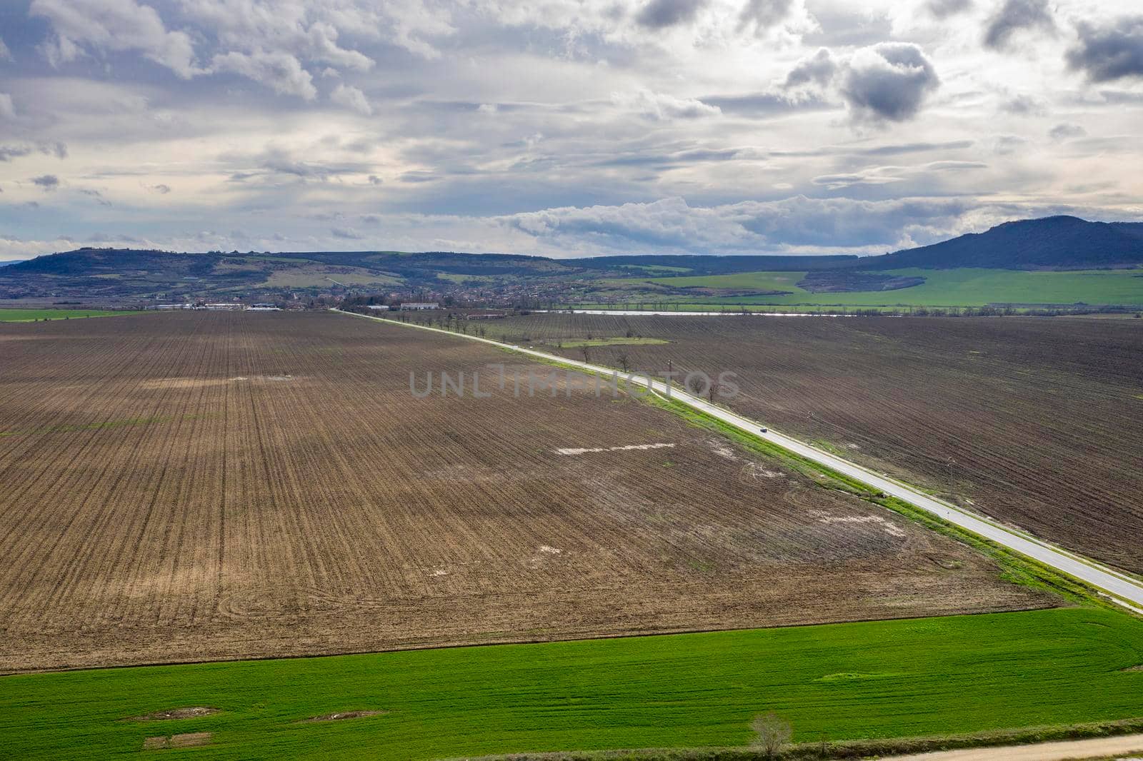 Amazing wide aerial view from drone of beautiful green countryside, fields, road, and cloudy sky by EdVal