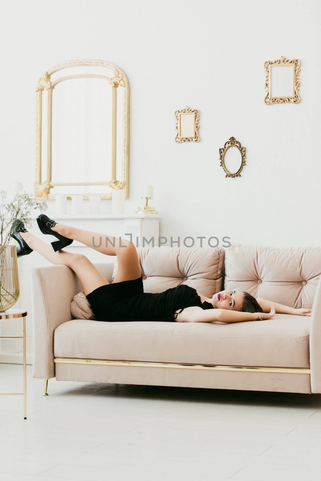 Photo of a women's legs in black high-heeled shoes with a buckle. Woman posing on a sofa by Ashtray25