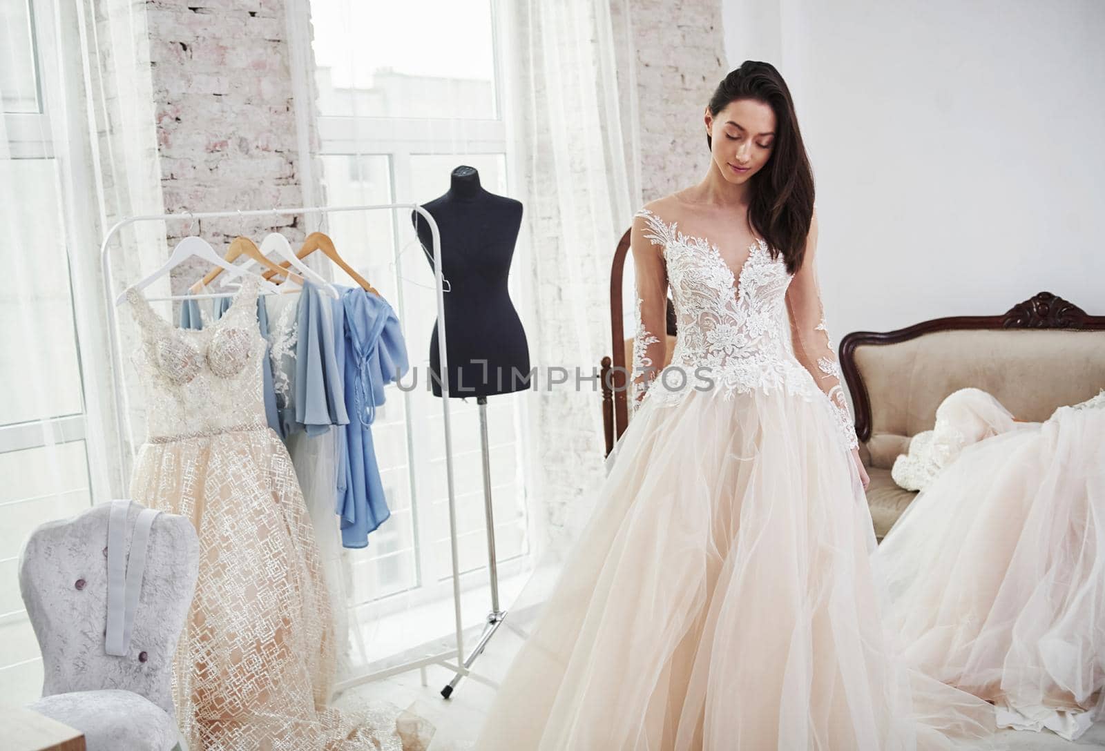 Standing in front of the mirror. The process of fitting the dress in the studio of hand crafted clothes.