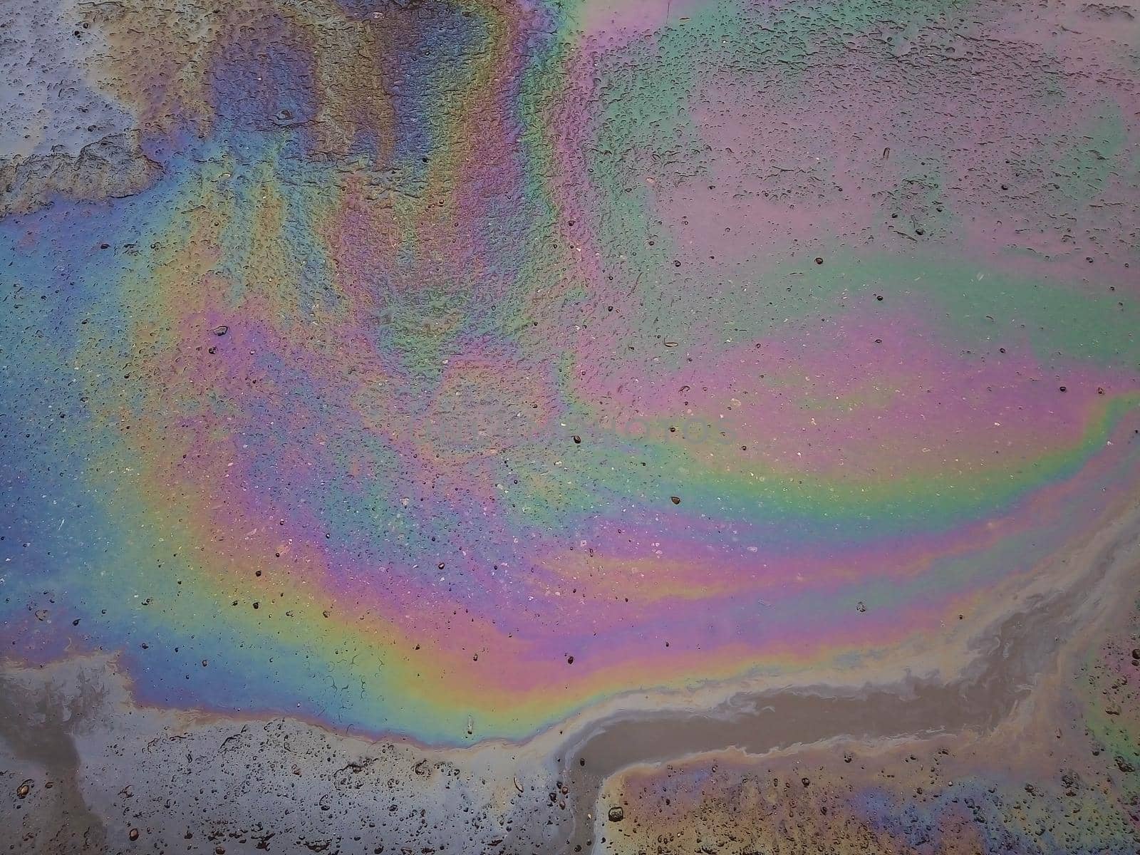 The color diluted with gasoline in a puddle. Environmental pollution.