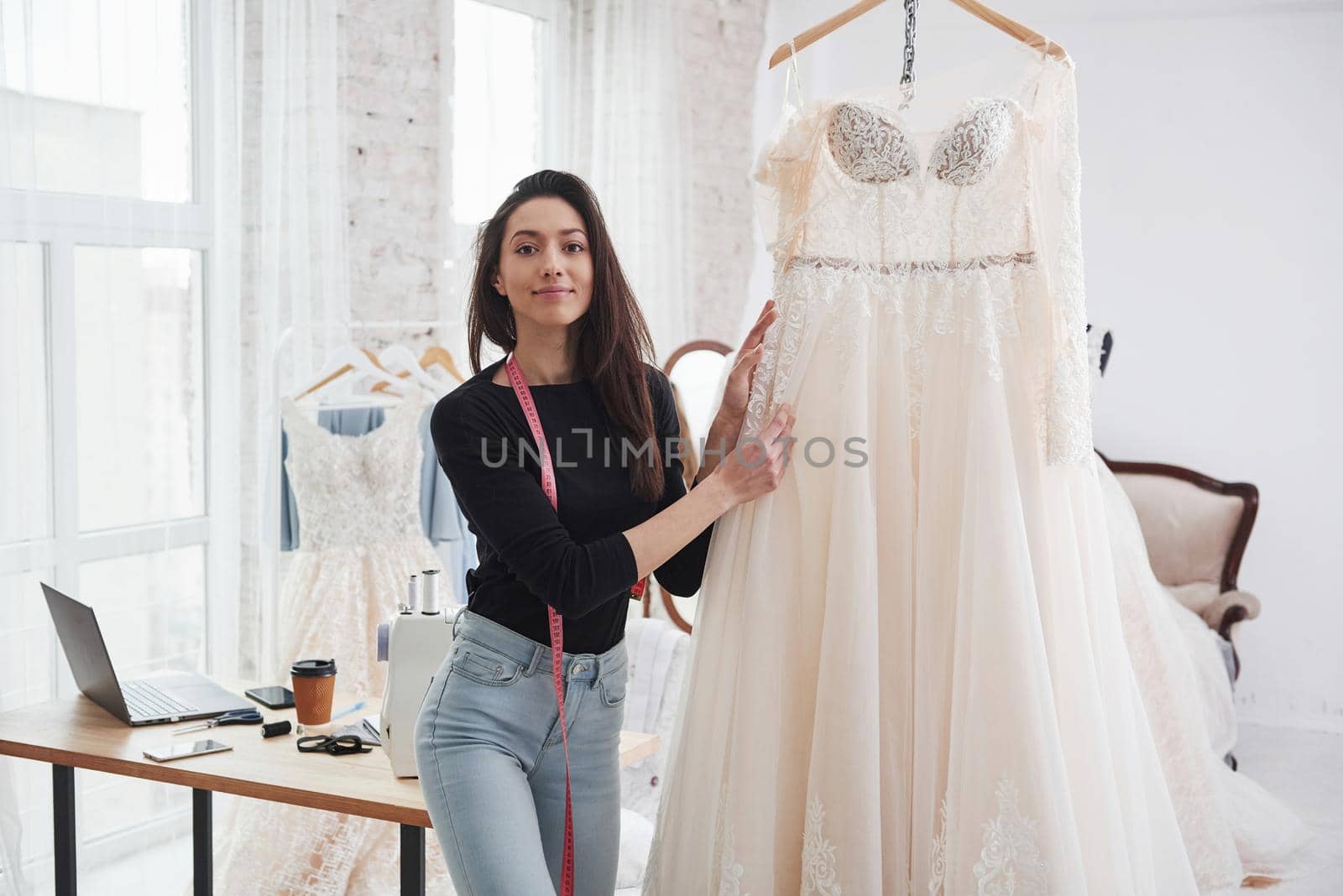 Showing off perfect dress. Female fashion designer works on the new clothes in the workshop.
