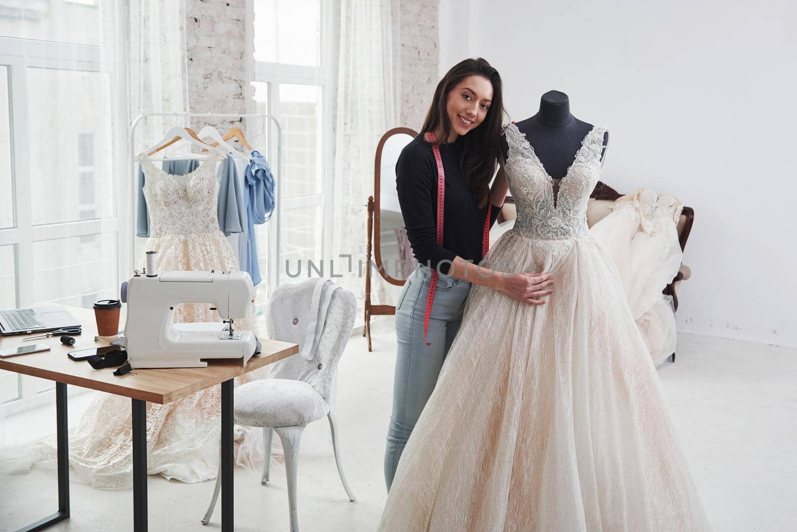 Look at her creation. Female fashion designer works on the new clothes in the workshop.