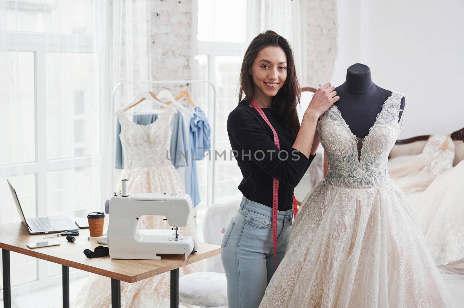 After hard job. Female fashion designer works on the new clothes in the workshop.