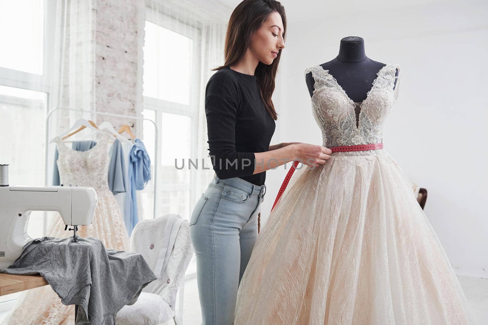 Concentrating at job. Female fashion designer works on the new clothes in the workshop.