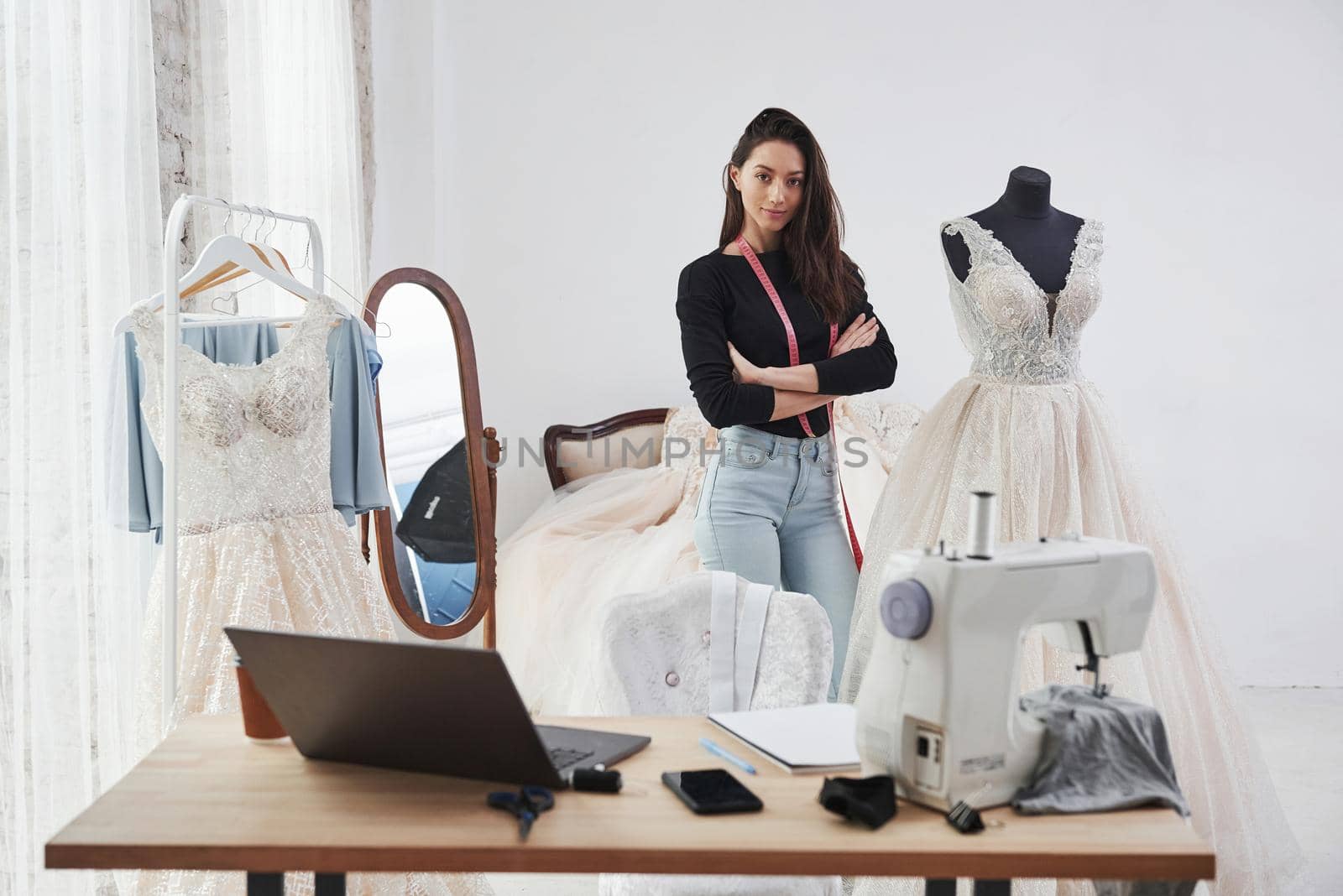 Nice day in clean room with proud owner. Female fashion designer works on the new clothes in the workshop.