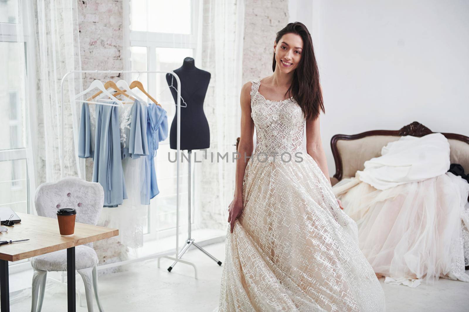 Bride is ready for the action. The process of fitting the dress in the studio of hand crafted clothes.