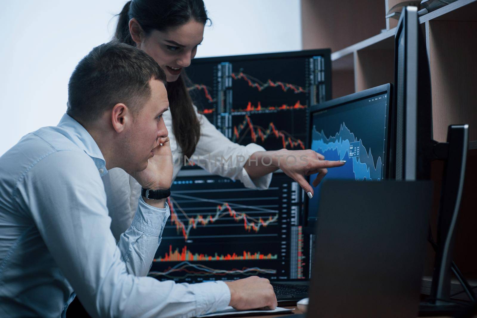 New working day has come. Team of stockbrokers are having a conversation in a office with multiple display screens.