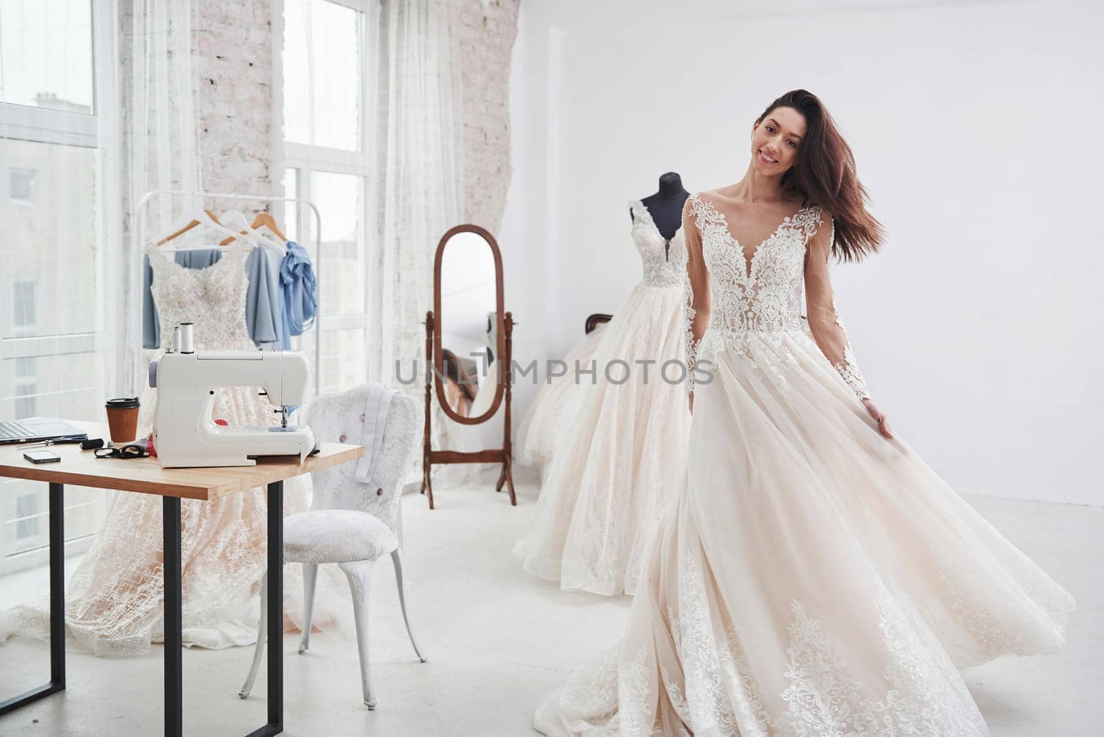 Bride is ready for her wedding. The process of fitting the dress in the studio of hand crafted clothes.