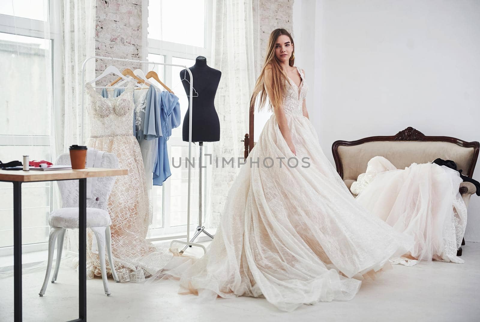 Beautiful blonde. The process of fitting the dress in the studio of hand crafted clothes.