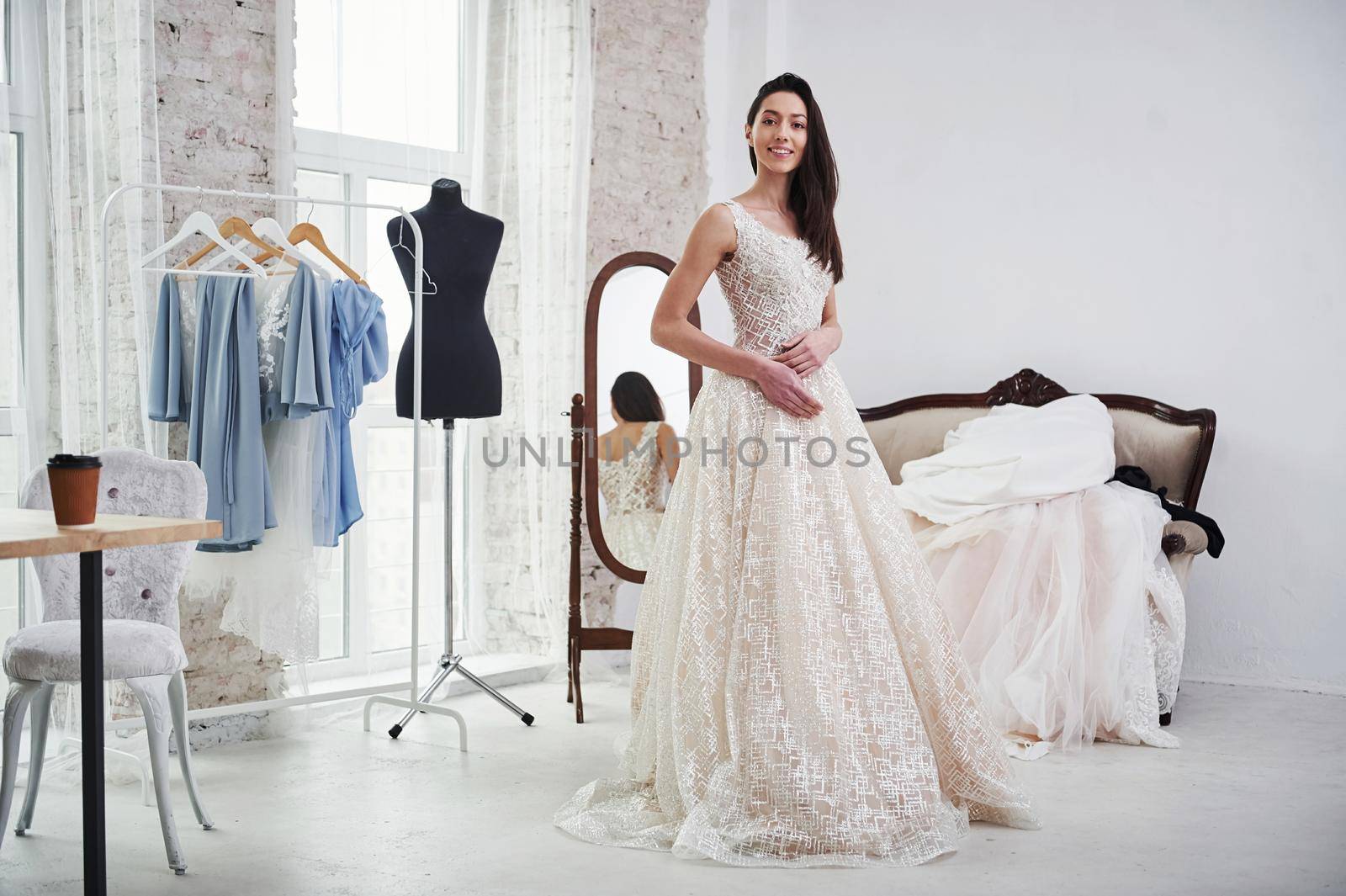 She satisfied. The process of fitting the dress in the studio of hand crafted clothes.