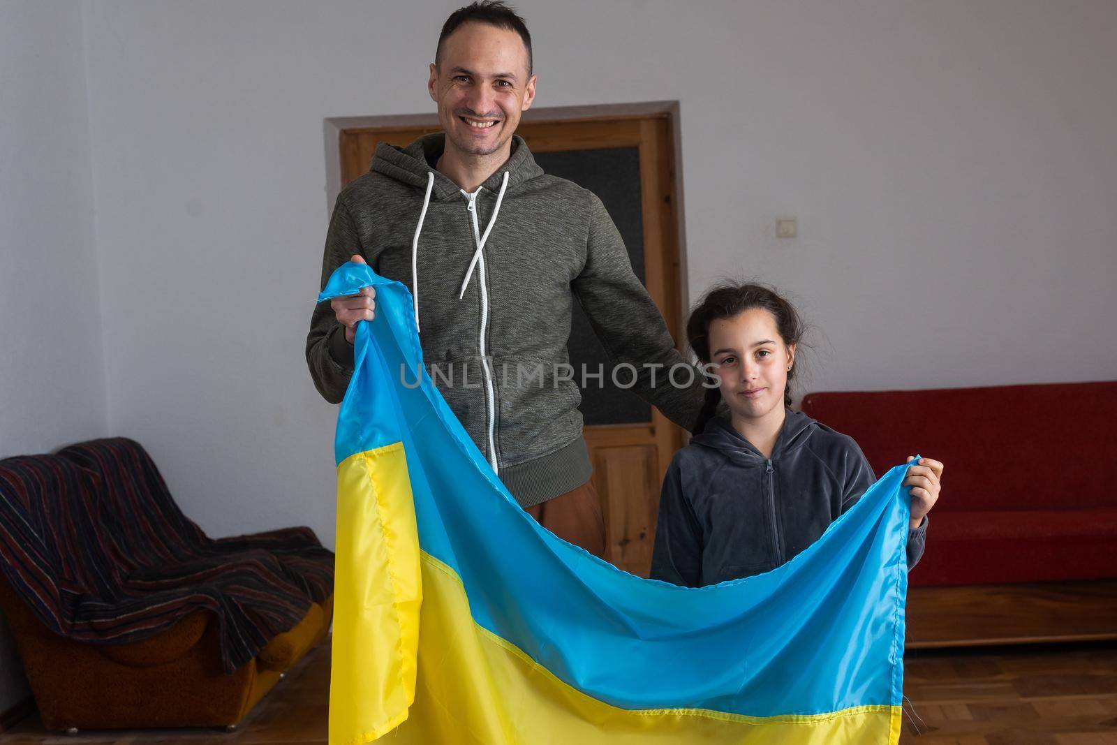 Father with daughter holding Ukrainian flag. Peace and pray for Ukraine.