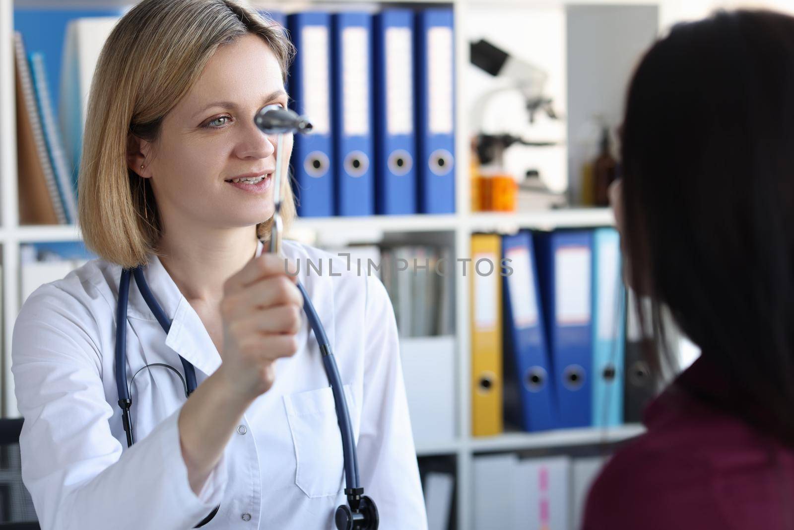 Neurologist holds hammer in front of patient eyes in clinic. Optic neuritis causes symptoms and treatment concept