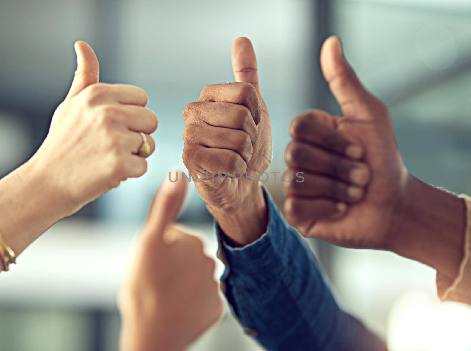 Heres to a job well done. Closeup shot of a group of businesspeople giving thumbs up together. by YuriArcurs