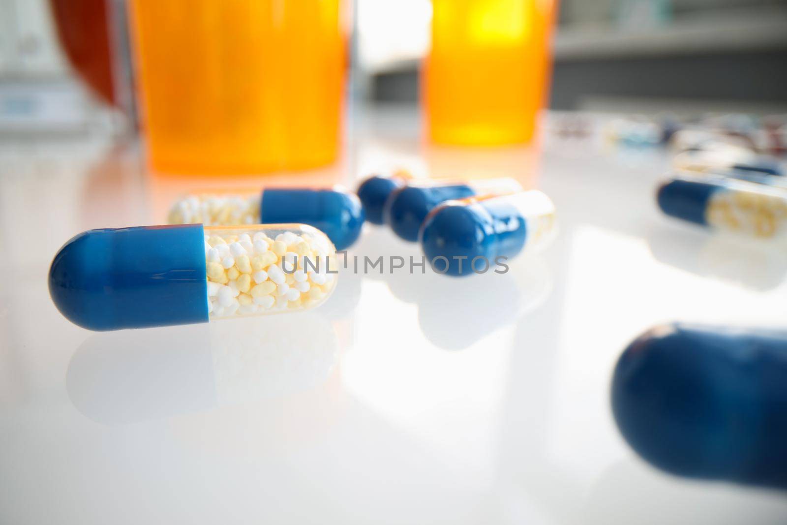 Medical pills capsules with granules on table closeup by kuprevich