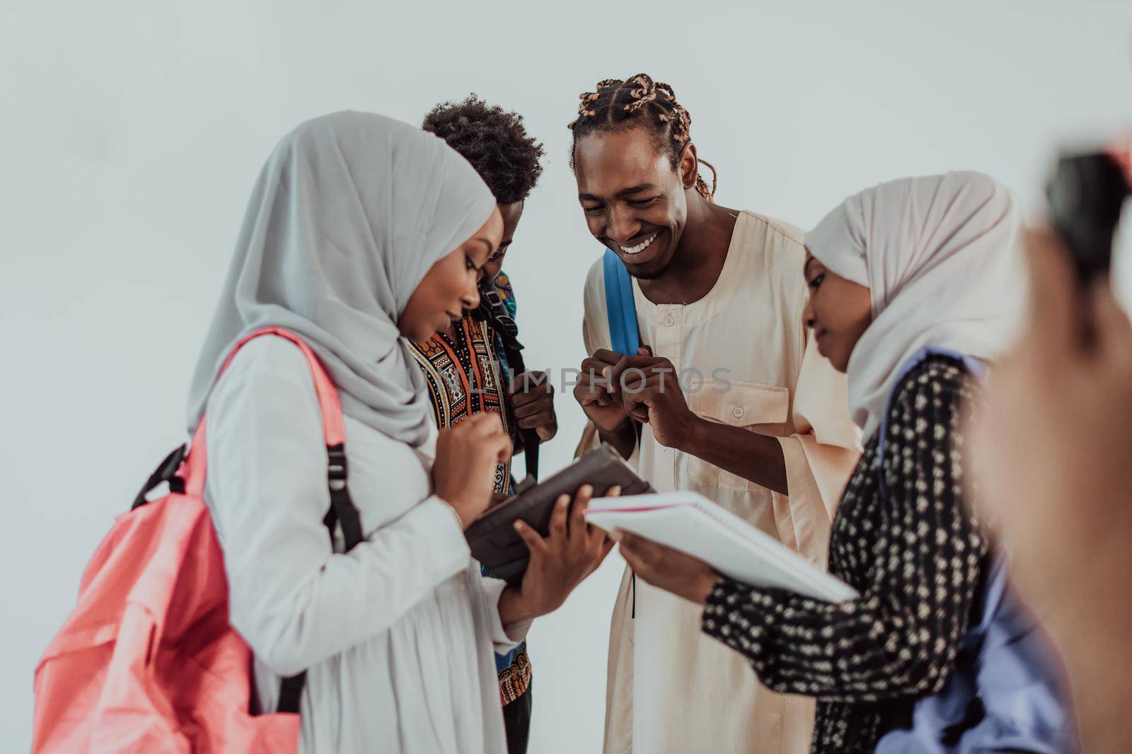 Group of happy african students having conversation and team meeting working together on homework girls wearing traidiional sudan muslim hijab fashion by dotshock