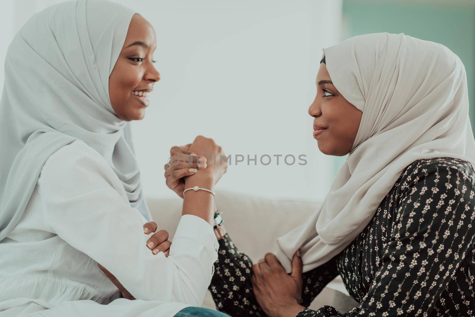 African woman arm wrestling conflict concept, disagreement and confrontation wearing traditional islamic hijab clothes. Selective focus by dotshock