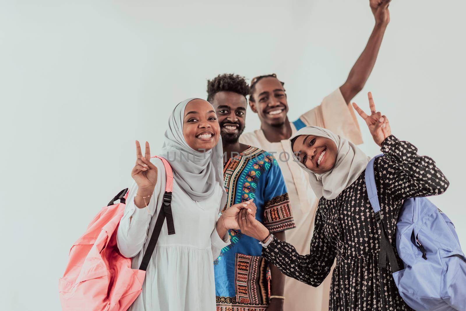 Group of happy african students having conversation and team meeting working together on homework girls wearing traidiional sudan muslim hijab fashion by dotshock