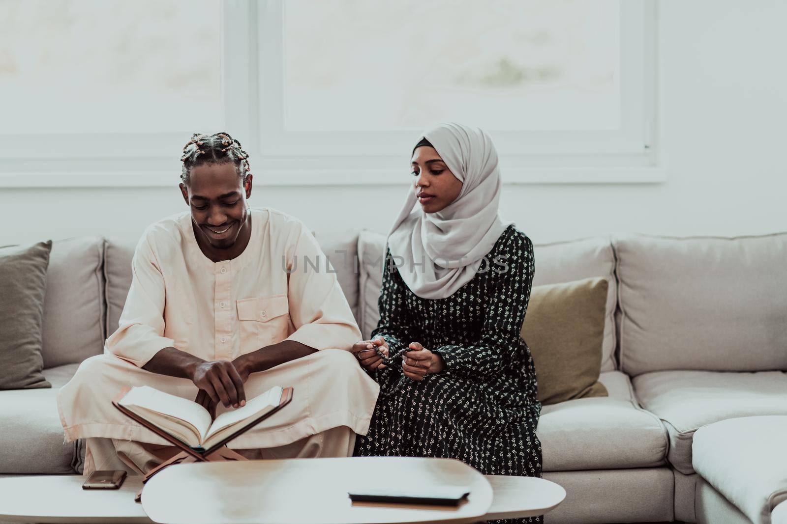 African Muslim couple at home in Ramadan reading Quran holly Islam book. High-quality photo