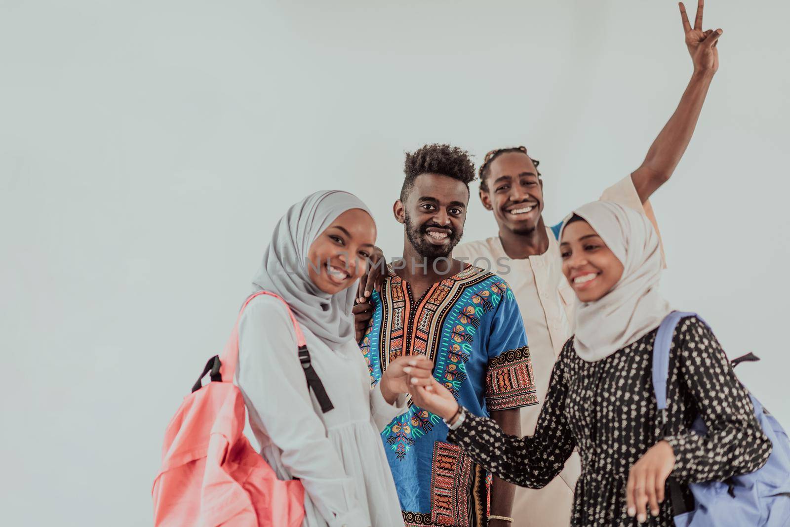 Group of happy african students having conversation and team meeting working together on homework girls wearing traidiional sudan muslim hijab fashion by dotshock