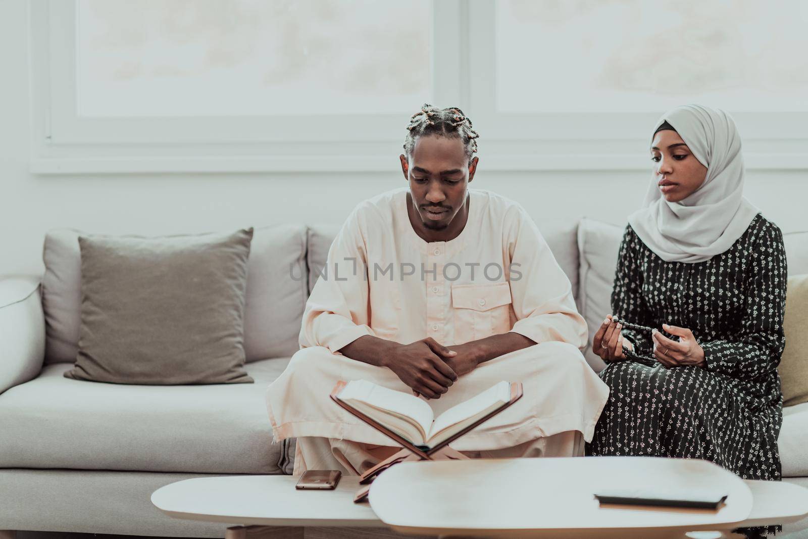 African Muslim couple at home in Ramadan reading Quran holly Islam book. High-quality photo