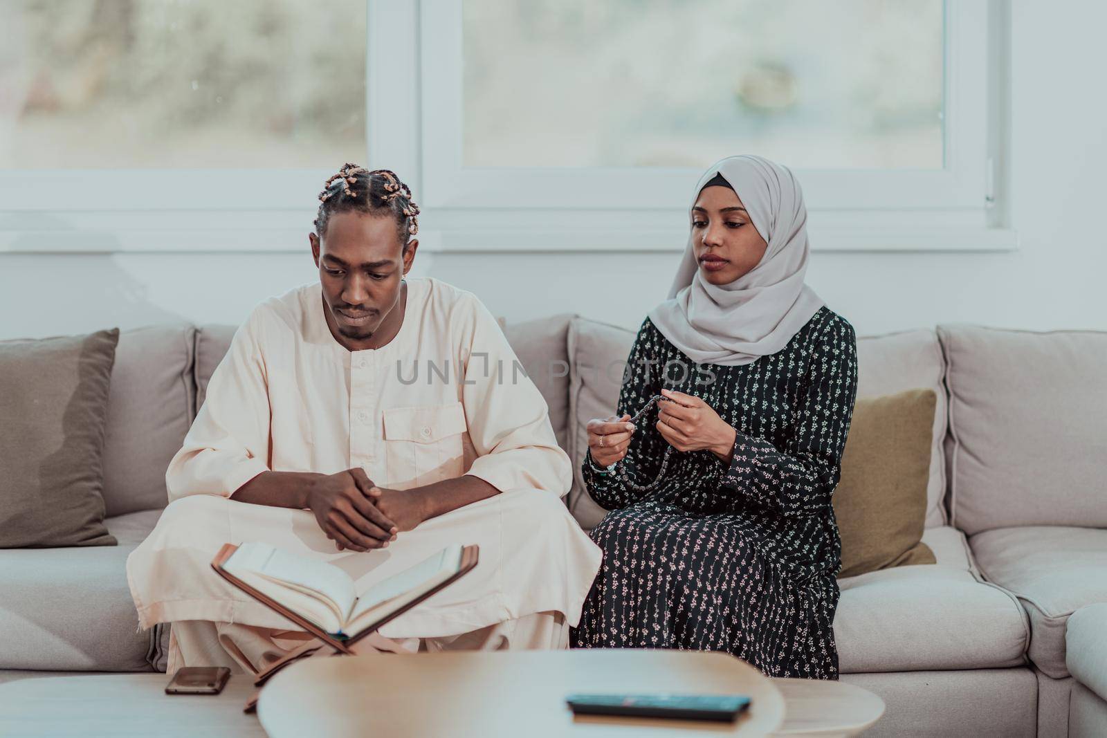 African Muslim couple at home in Ramadan reading Quran holly Islam book. High-quality photo