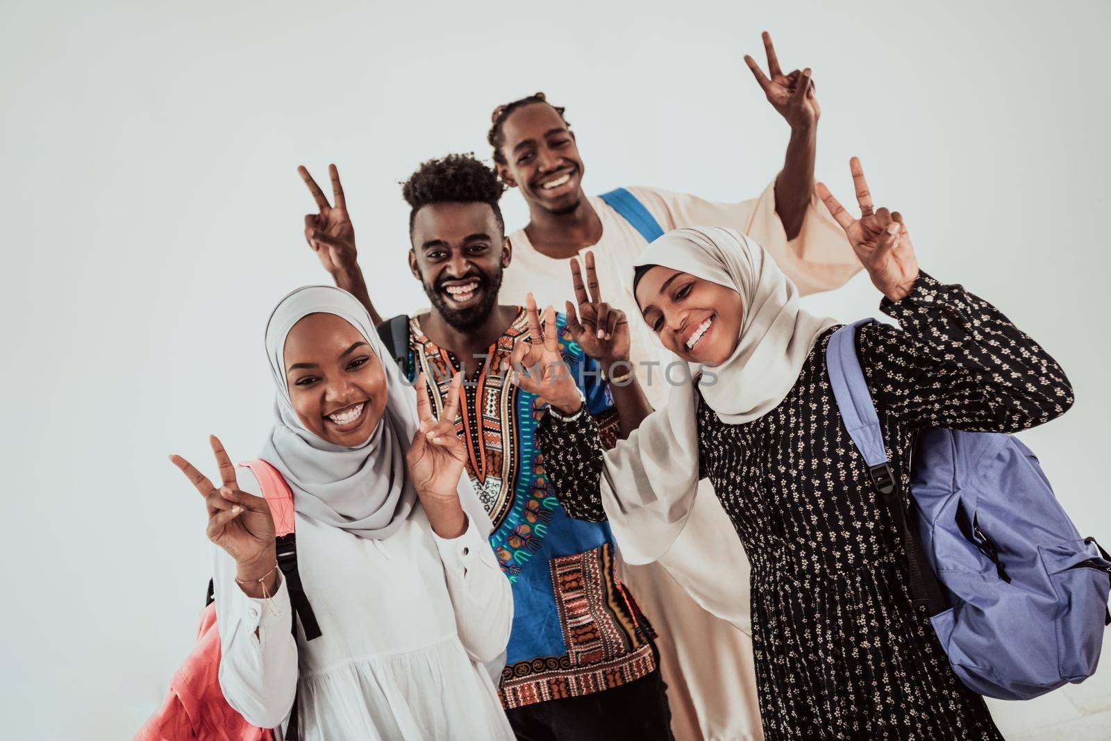 Group of happy african students having conversation and team meeting working together on homework girls wearing traidiional sudan muslim hijab fashion by dotshock