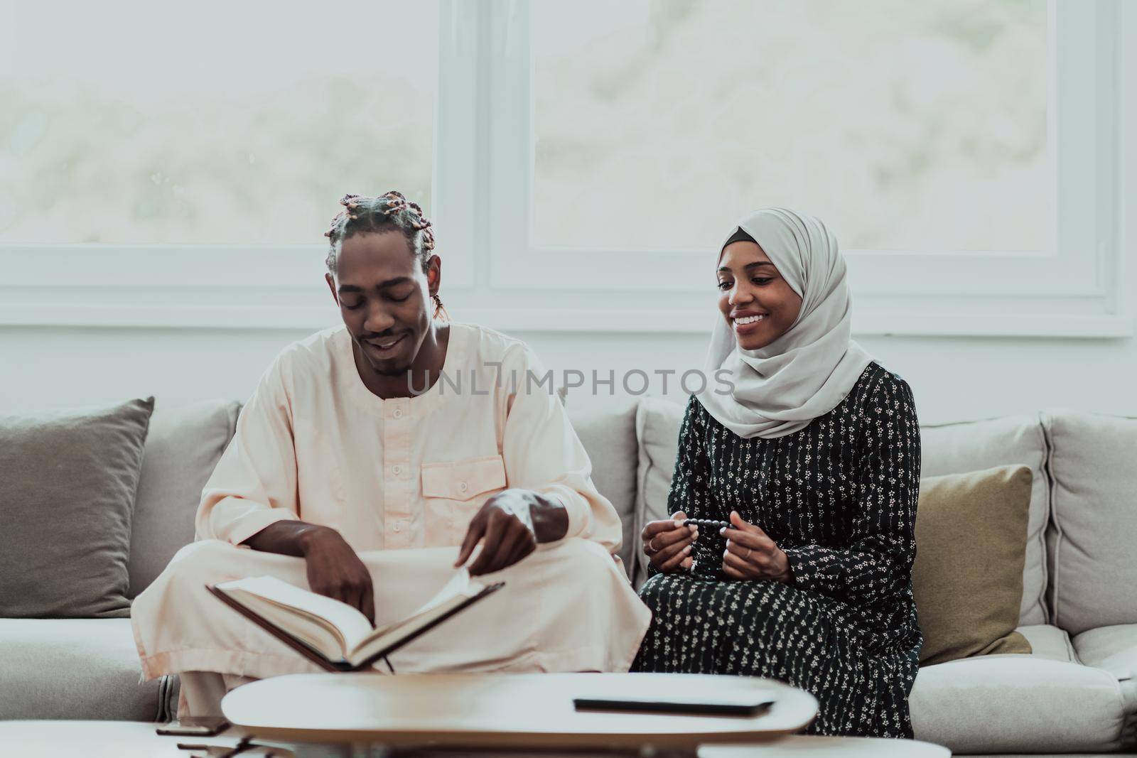 African Muslim couple at home in Ramadan reading Quran holly Islam book. by dotshock